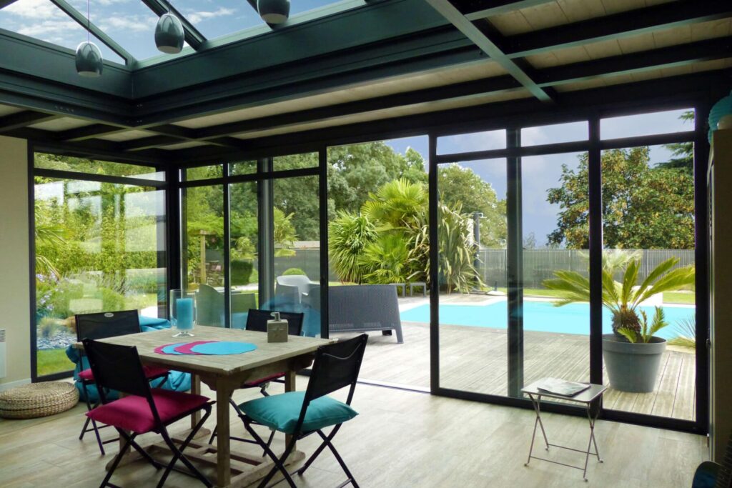 intérieur d'extension d'une maison donnant sur une terrasse avec une piscine en normandie