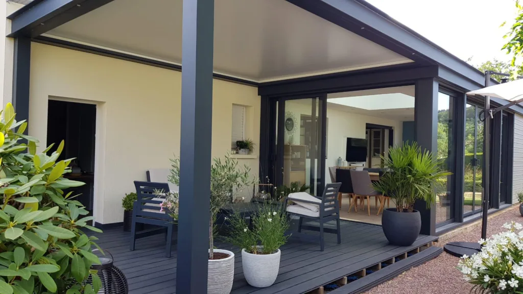 pergola bioclimatique normandie concept alu posée contre avec une extension de maison avec une terrasse aménagée en normandie